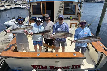 Smiling family fishing near Kure Beach on the Wild Rover III